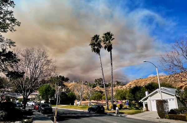 A large plume of smoke rises from Castaic Lake seen behind a neighborhood in Santa Clarita, Calif. on Wednesday, Jan. 22, 2025. (AP Photo/Marcio Jose Sanchez)