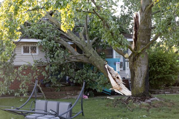 A tree lays on a house in Dorr, Mich., after a severe storm ripped across Michigan the night before, on Friday, May 16. 2025. (Neil Blake /The Grand Rapids Press via AP)