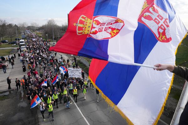 Students walk on the road towards the northern city of Novi Sad, where they will participate in a 24 hour block of three bridges to protest the deaths of 15 people killed in the November collapse of a train station canopy, near the Belgrade suburb of Batajnica, Serbia, Thursday, Jan. 30, 2025. (AP Photo/Darko Vojinovic)