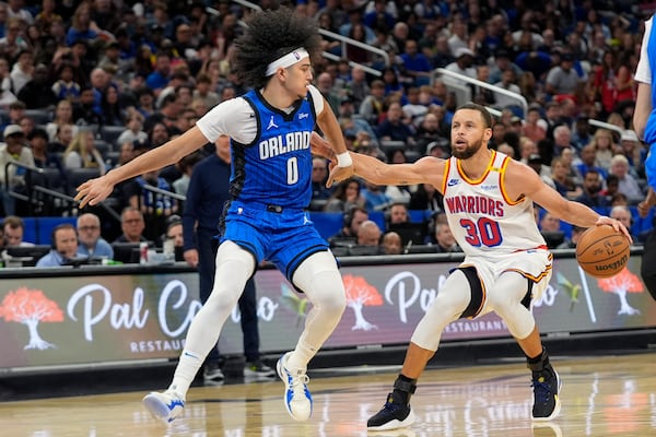 Golden State Warriors guard Stephen Curry (30) pulls up for a shot as Orlando Magic guard Anthony Black (0) tries to defend during the second half of an NBA basketball game, Thursday, Feb. 27, 2025, in Orlando, Fla. (AP Photo/John Raoux)