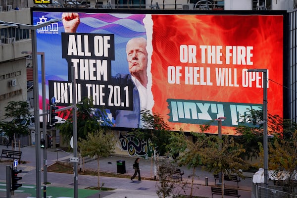 An electronic billboard beams an image of President-elect Donald Trump and references his threat to unleash hell if hostages held in Gaza are not freed until his inauguration later this month. in Tel Aviv, Israel, on Wednesday, Jan. 8, 2025. (AP Photo/Oded Balilty)