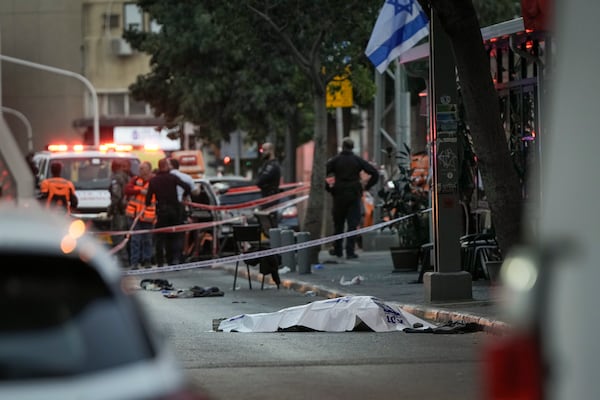 The body of a man who attacked pedestrians with a knife lies covered on the street after he was shot during the stabbing incident in Tel Aviv, Israel, Saturday Jan. 18, 2025.(AP Photo/Oded Balilty)