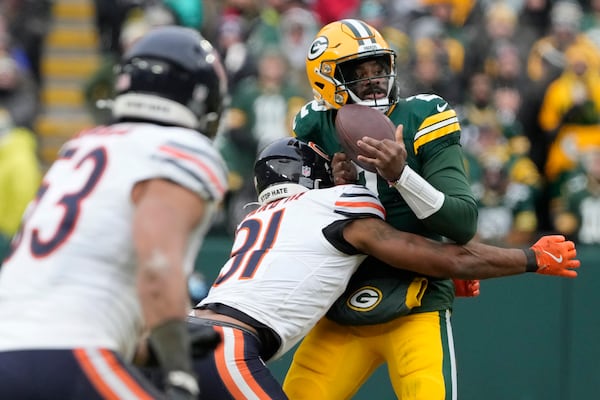 Chicago Bears safety Kevin Byard III, middle, forces Green Bay Packers quarterback Malik Willis to fumble the ball, which was recovered by the Bears, during the second half of an NFL football game, Sunday, Jan. 5, 2025, in Green Bay, Wis. (AP Photo/Morry Gash)