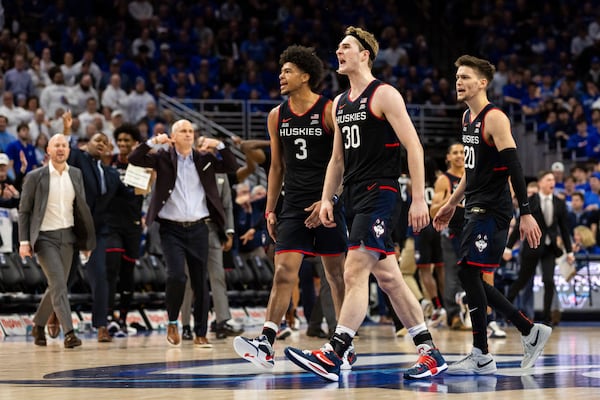 UConn forwards Jaylin Stewart (3) and Liam McNeeley (30) and guard Aidan Mahaney (20) react after a basket against Creighton during the second half of an NCAA college basketball game, Tuesday, Feb. 11, 2025, in Omaha, Neb. (AP Photo/Bonnie Ryan)