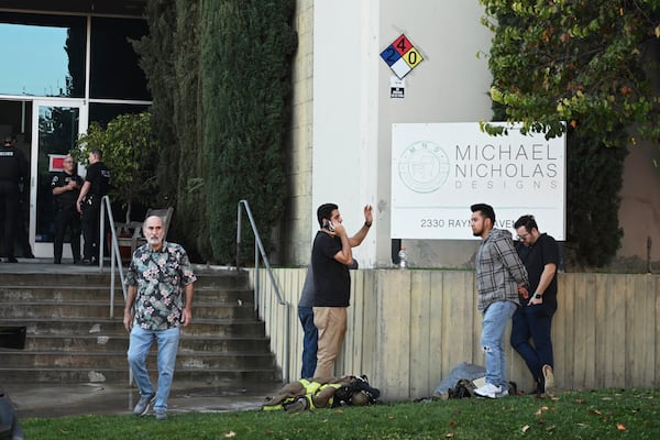 People stand outside of a building where a plane crash occurred Thursday, Jan. 2, 2025, in Fullerton, Calif. (AP Photo/Kyusung Gong)