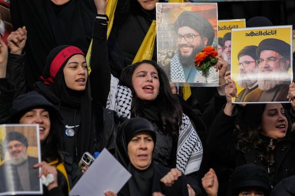 Mourners react as a trailer carrying the coffins containing the bodies of Hezbollah's former leader Hassan Nasrallah and his cousin and successor Hashem Safieddine drives through the crowd at the beginning of a funeral procession in the Sports City Stadium in Beirut, Lebanon, Sunday, Feb. 23, 2025. (AP Photo/Hussein Malla)