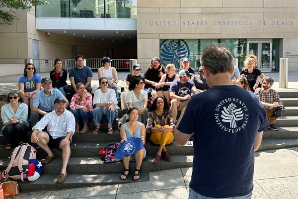 U.S. Institute of Peace employees hold an impromptu celebration on the steps of the U.S. Institute of Peace, Monday, May 19, 2025, in Washington, after federal district Judge Beryl A. Howell blocked the Trump administration from moving forward with dismantling the organization. (AP Photo/Gary Fields)