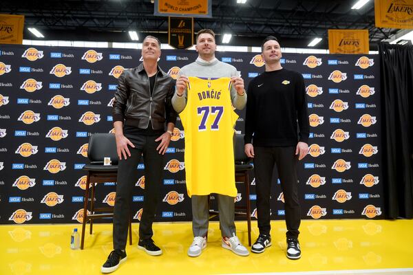 From left to right, Los Angeles Lakers general manager Rob Pelinka, Luka Doncic, and head coach JJ Redick pose for photos during an introductory NBA basketball press conference Tuesday, Feb. 4, 2025, in El Segundo, Calif. (AP Photo/Jae C. Hong)