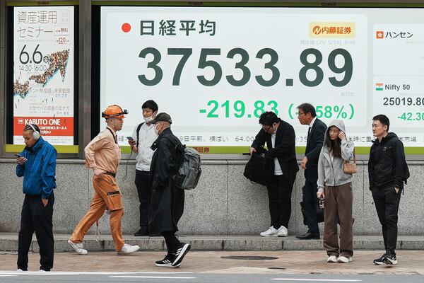 People stand in front of an electronic stock board showing Japan's Nikkei index at a securities firm Monday, May 19, 2025, in Tokyo. (AP Photo/Eugene Hoshiko)