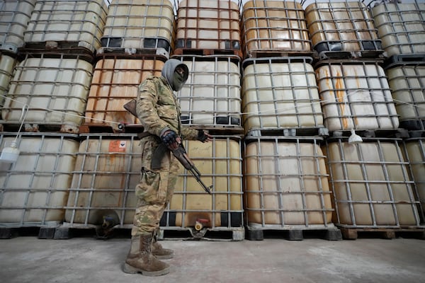 A Syrian member of the rebel group shows liquid material for manufacturing amphetamine pills known as Captagon hidden, at the warehouse where the drug was manufactured before the fall of Bashar Assad government at a facility in Douma city, outskirts of Damascus, Syria, Friday, Dec. 13, 2024. (AP Photo/Hussein Malla)