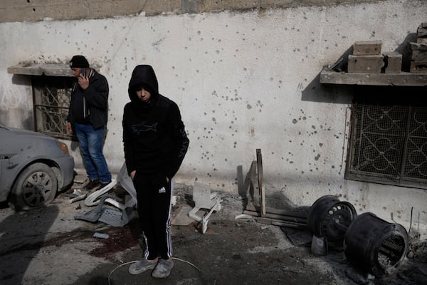 People look at the site where six Palestinians were killed in an Israeli airstrike in Jenin refugee camp, West Bank, on Wednesday, Jan. 15, 2025. (AP Photo/Majdi Mohammed)