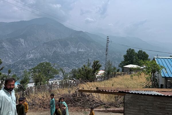Villager walk on a dusty track during a government's organized trip for media to Bella Noor Shah, a mountainous village near Muzaffarabad, the capital of Pakistan administered Kashmir, Monday, May 5, 2025. (AP Photo/Muhammad Yousuf, Pool)