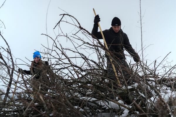 Daniel Stevens, right, tries to startle small game out of a brush pile while hunting with his mother, Stephanie, left, Friday, Feb. 14, 2025, in Greenleaf, Wis. (AP Photo/Joshua A. Bickel)