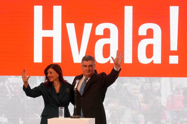 President incumbent Zoran Milanovic with his wife Sanja Music Milanovic greets his supporters as the preliminary results grant him victory in a runoff vote for the Croatian presidential election in Zagreb, Croatia, Sunday, Jan. 12, 2025. The sign reads "Thank You". (AP Photo/Darko Bandic)