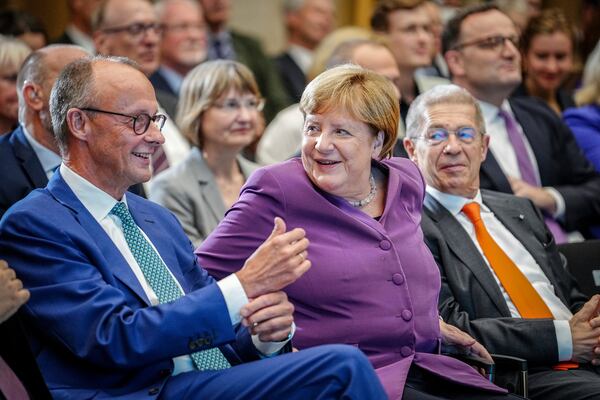 FILE - Former German Chancellor Angela Merkel and CDU Federal Chairman and CDU parliamentary group leader Friedrich Merz, left, take part in the Berlin special discussion on the former Chancellor's 70th birthday, in Berlin, Sept, 25, 2024. (Kay Nietfeld/dpa via AP)