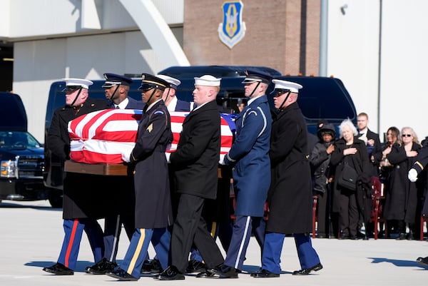 A joint forces military body bearer team moves flag-draped casket of former President Jimmy Carter to Special Air Mission 39 at Dobbins Air Reserve Base in Marietta, Ga., Tuesday, Jan. 7, 2025. Carter died Dec. 29 at the age of 100. (AP Photo/Alex Brandon, Pool)