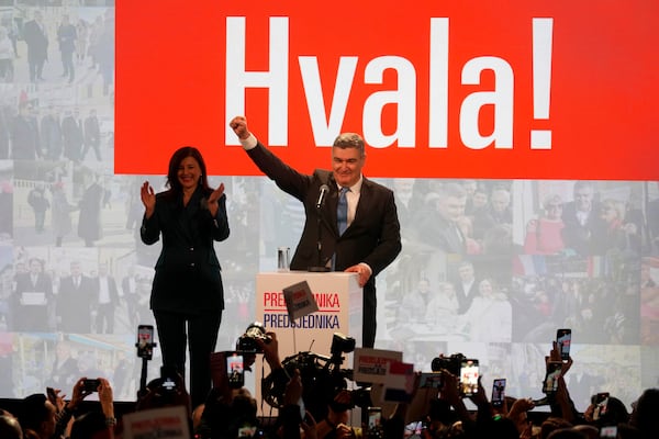 President incumbent Zoran Milanovic with his wife Sanja Music Milanovic greets supporters as the preliminary results grant him victory in a runoff vote for the Croatian presidential election in Zagreb, Croatia, Sunday, Jan. 12, 2025. The sign reads "Thank You". (AP Photo/Darko Bandic)