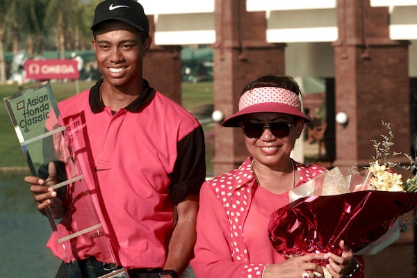 FILE - Golf sensation Tiger Woods, left, poses with his mother Kultida while holding his trophy and key to a new car after winning the Asian Honda Classic in Bangkok, Thailand, Sunday, Feb. 9, 1997. (AP Photo/Charles Dharapak, File)