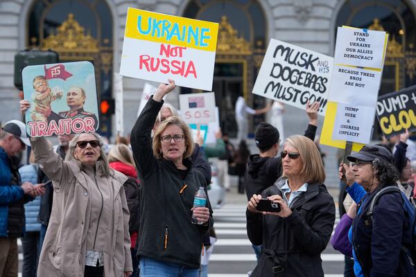 People hold up signs to protest the Trump administration Tuesday, March 4, 2025, in San Francisco. (AP Photo/Godofredo A. Vásquez)