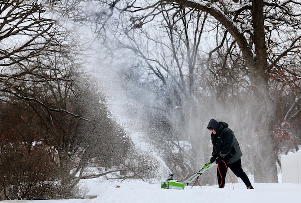 Dave Thomasson uses an electric snowblower to clear his driveway in the Webster Oaks subdivision of Webster Groves, Mo. as residents started clearing a path on Monday, Jan. 6, 2025. (Robert Cohen/St. Louis Post-Dispatch via AP)