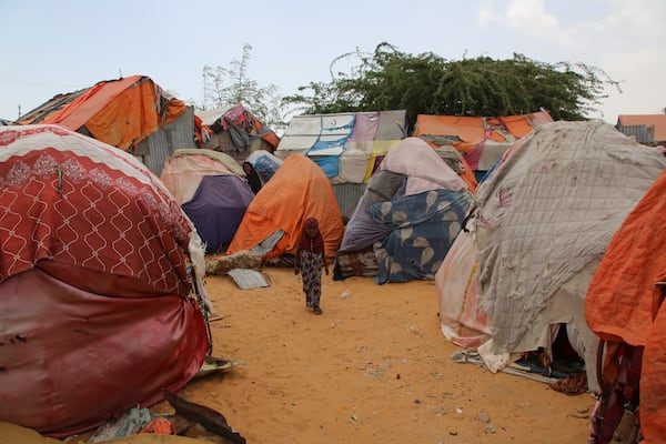 A Somali internally-displaced person (IDP) child walks past makeshift homes in Maslah camp on the outskirts of Mogadishu, Somalia Wednesday, Feb. 5, 2025. (AP Photo/Farah Abdi Warsameh)