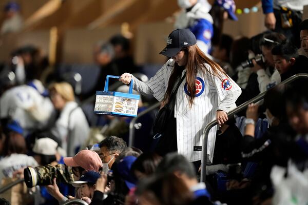 A Chicago Cubs fan makes her way to her seat before an MLB Tokyo Series baseball game against the Los Angeles Dodgers in Tokyo, Japan, Wednesday, March 19, 2025. (AP Photo/Hiro Komae)