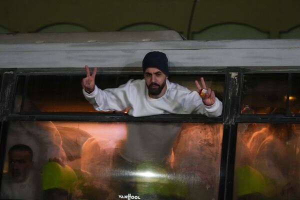 Freed Palestinian prisoners wave from a bus as they arrive in the Gaza Strip after being released from an Israeli prison following a ceasefire agreement between Hamas and Israel in Khan Younis, Gaza Strip, Thursday, Feb. 27, 2025. (AP Photo/Abdel Kareem Hana)