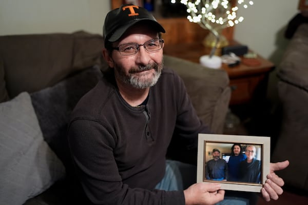 Jerry Barnett holds a picture of his wife and son on Nov. 22, 2024, in Johnson City, Tenn. Barnett's wife, Sibrina, died trying to escape flood waters caused by Hurricane Helene in September, near the plastics factory where she cleaned offices once a week. (AP Photo/George Walker IV)