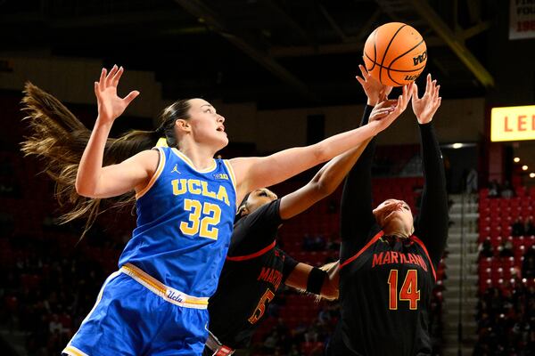 UCLA forward Angela Dugalic (32) battle for the ball against Maryland forward Christina Dalce, center, and forward Allie Kubek (14) during the second half of an NCAA college basketball game, Sunday, Jan. 26, 2025, in College Park, Md. (AP Photo/Nick Wass)