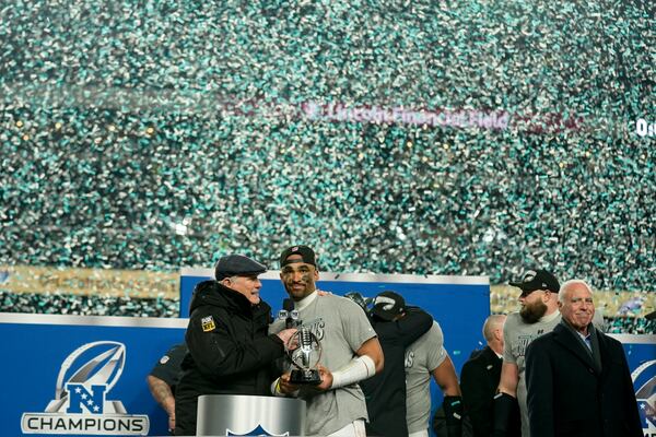 Philadelphia Eagles quarterback Jalen Hurts celebrates with the trophy after their win against the Washington Commanders in the NFC Championship NFL football game, Sunday, Jan. 26, 2025, in Philadelphia (AP Photo/Seth Wenig)