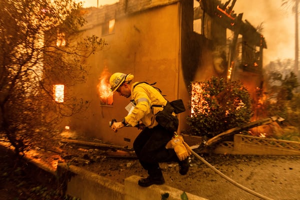 A firefighter battles the Eaton Fire Wednesday, Jan. 8, 2025 in Altadena, Calif. (AP Photo/Ethan Swope)