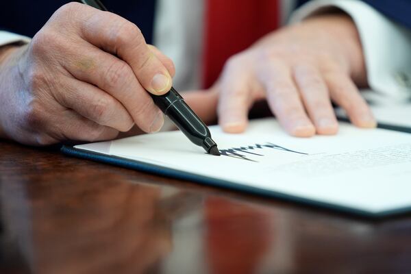 President Donald Trump signs an executive order in the Oval Office of the White House, Monday, Feb. 3, 2025, in Washington. (AP Photo/Evan Vucci)