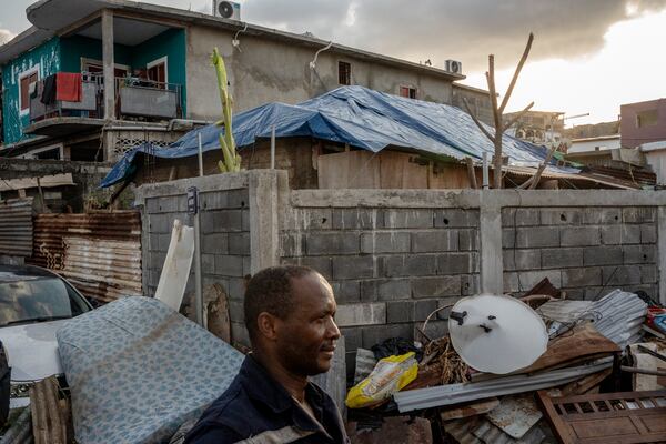 Firefighters and the civil security put tarp on houses of vulnerable people in Mamoudzou, Mayotte, Thursday, Dec. 19, 2024 (AP Photo/Adrienne Surprenant)