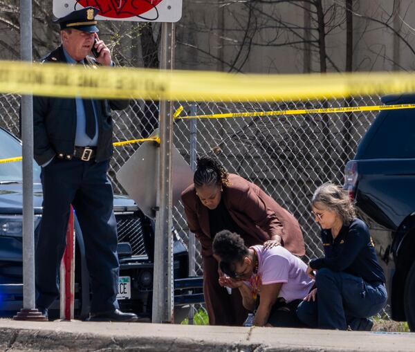A police officer works on the scene as a bystander is shook up by the homicide in front of 2107 Cedar Ave S in Minneapolis, Minn., on Wednesday, April 30, 2025. (Richard Tsong-Taatarii/Star Tribune via AP)