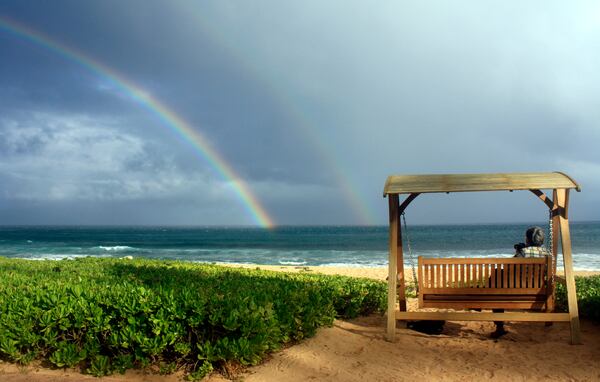 FILE - Joseph Heher photographs rainbows at Shipwreck's Beach, Grand Hyatt Kauai, Hawaii, July 2, 2010, in Hawaii. (AP Photo/Ashley Heher, File)