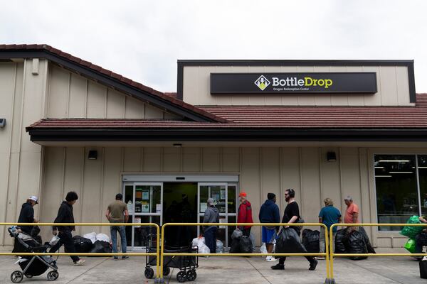 People wait in line outside the Glisan BottleDrop Redemption Center on Thursday, May 15, 2025, in Portland, Ore. (AP Photo/Jenny Kane)