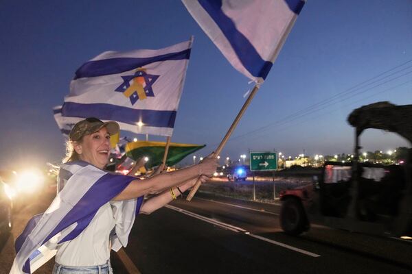 Israelis wave flags as the convoy carrying freed Israeli-American soldier Edan Alexander arrives after his release from Hamas captivity in Gaza to an army base in Reim, near the Gaza border, southern Israel, Monday, May 12, 2025.(AP Photo/Maya Alleruzzo)