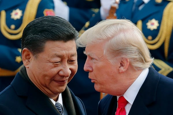 FILE - President Donald Trump, right, talks with China's President Xi Jinping during a welcome ceremony at the Great Hall of the People in Beijing, Nov. 9, 2017. (AP Photo/Andy Wong, File)