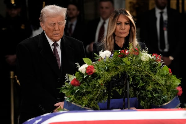 President-elect Donald Trump and Melania Trump pause at the flag-draped casket of former President Jimmy Carter as he lies in state in the rotunda of the U.S. Capitol in Washington, Wednesday, Jan. 8, 2025. (AP Photo/J. Scott Applewhite)