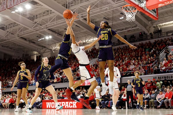 North Carolina State's Zoe Brooks, center, attempts to shoot between Notre Dame's Liatu King (20) and Sonia Citron (11) during the second half of an NCAA college basketball game in Raleigh, N.C., Sunday, Feb. 23, 2025. (AP Photo/Ben McKeown)