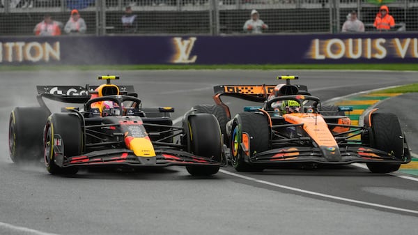 McLaren driver Lando Norris, right, of Britain and Red Bull driver Liam Lawson of New Zealand complete to get out of turn two during the Australian Formula One Grand Prix at Albert Park, in Melbourne, Australia, Sunday, March 16, 2025. (AP Photo/Asanka Brendon Ratnayake)