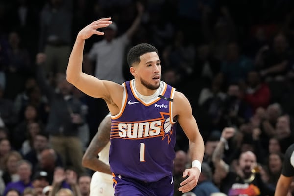 Phoenix Suns guard Devin Booker celebrates his 3-pointer against the Minnesota Timberwolves during the first half of an NBA basketball game Wednesday, Jan. 29, 2025, in Phoenix. (AP Photo/Ross D. Franklin)