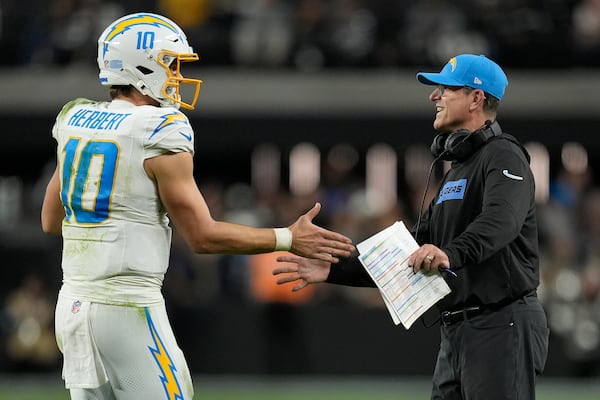 Los Angeles Chargers quarterback Justin Herbert (10) celebrates with head coach Jim Harbaugh during the second half of an NFL football game against the Las Vegas Raiders in Las Vegas, Sunday, Jan. 5, 2025. (AP Photo/John Locher)