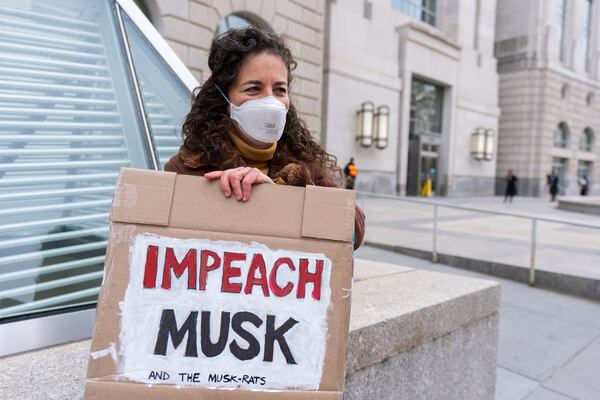 A United States Agency for International Development, or USAID contract worker, carries a sign outside the USAID headquarters in Washington, Monday, Feb. 10, 2025. (AP Photo/Manuel Balce Ceneta)