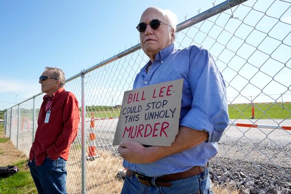 John Lozier, an anti-death penalty protester, holds a sign making reference to Gov. Bill Lee as he stands outside Riverbend Maximum Security Institution before the execution of Oscar Smith Thursday, May 22, 2025, in Nashville, Tenn. (AP Photo/Mark Humphrey)