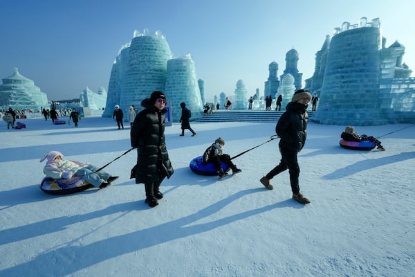 People pull their children on inflatable tubes as they visit the Harbin Ice and Snow World in Harbin, China's Heilongjiang province on Jan. 6, 2025. (AP Photo/Andy Wong)