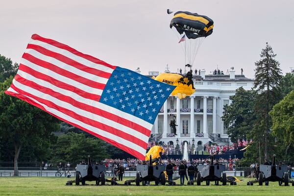 FILE - President Donald Trump and first lady Melania Trump watch as the U.S. Army Golden Knights Parachute Team descend during a "Salute to America" event on the South Lawn of the White House, July 4, 2020, in Washington. (AP Photo/Alex Brandon, File)