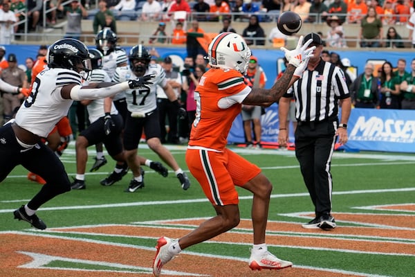 Miami wide receiver Jacolby George, right, makes a catch for a touchdown in front of Iowa State defensive back Ta'Shawn James during the first half of the Pop Tarts Bowl NCAA college football game, Saturday, Dec. 28, 2024, in Orlando, Fla. (AP Photo/John Raoux)