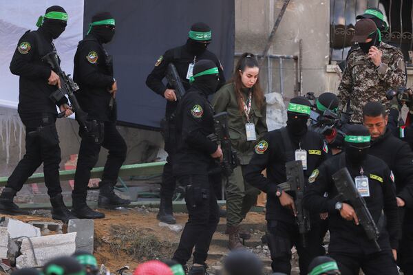 Israeli soldier Agam Beger walks next to masked Islamic Jihad militants as she is handed over to the Red Cross at the Jabalya refugee camp in Gaza City, Thursday Jan. 30, 2025.(AP Photo/Mohammed Hajjar)