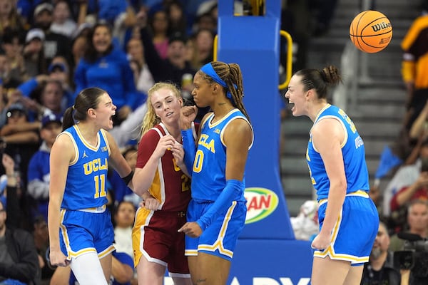 UCLA forward Angela Dugalic, right, celebrates along with guard Gabriela Jaquez, left, and forward Janiah Barker, second from right, after scoring while Southern California guard Avery Howell tries to through during the first half of an NCAA college basketball game Saturday, March 1, 2025, in Los Angeles. (AP Photo/Mark J. Terrill)